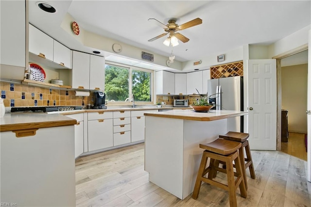 1737 Pleasant Ridge Rd, Virginia Beach, VA 23457 - kitchen with ceiling fan, white cabinets, light wood-style floors, tasteful backsplash, and light countertops