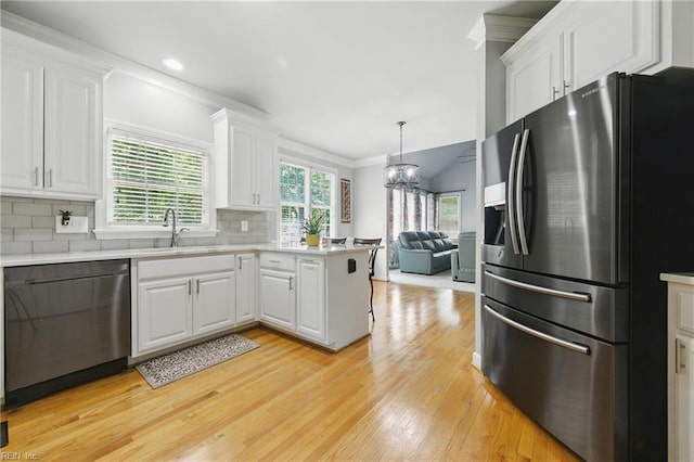 20517 Madison Ct, Smithfield, VA 23430 - kitchen with stainless steel appliances, crown molding, light wood-style flooring, white cabinets, and backsplash