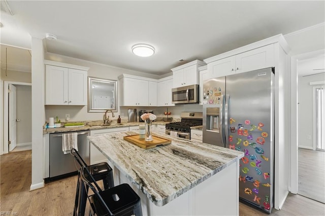 1832 Andrews Blvd, Hampton, VA 23663 - kitchen with stainless steel appliances, white cabinetry, light stone countertops, light wood-style floors, and ornamental molding