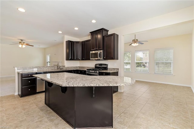 3112 Sybilla St, Chesapeake, VA 23323 - kitchen with appliances with stainless steel finishes, ceiling fan, a peninsula, light stone countertops, and recessed lighting