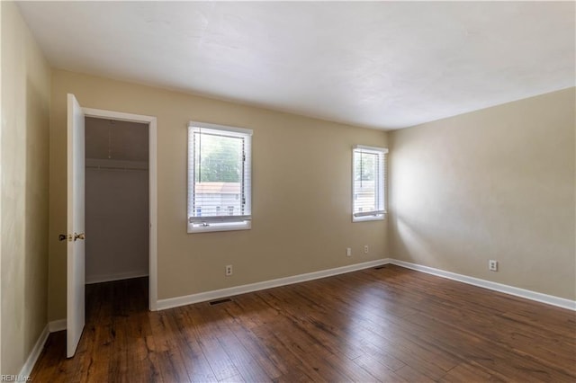 3724 Radford Cir, Chesapeake, VA 23321 - unfurnished bedroom with multiple windows, a walk in closet, hardwood / wood-style floors, and a closet