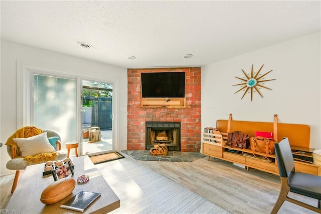 1509 Cypress Ave, Virginia Beach, VA 23451 - living area featuring wood finished floors, a brick fireplace, and a textured ceiling