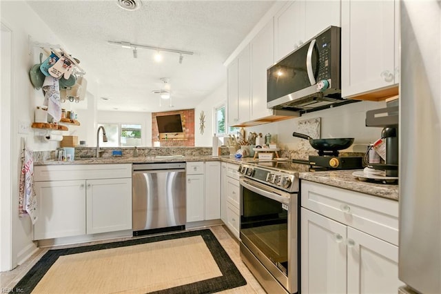 1509 Cypress Ave, Virginia Beach, VA 23451 - kitchen featuring appliances with stainless steel finishes, white cabinets, light stone countertops, a textured ceiling, and ceiling fan