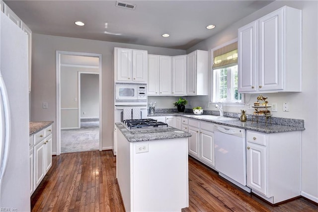 6667 Rexford Ln, Williamsburg, VA 23188 - kitchen with white appliances, a center island, white cabinetry, dark wood finished floors, and recessed lighting