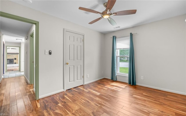 2504 Pine Needles Cir, Virginia Beach, VA 23453 - unfurnished bedroom featuring light wood-style flooring, a stone fireplace, and a ceiling fan