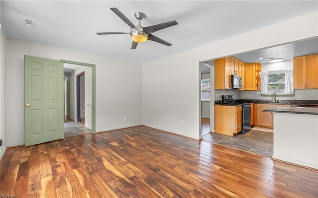2504 Pine Needles Cir, Virginia Beach, VA 23453 - kitchen with electric range, black microwave, wood finished floors, dark countertops, and a ceiling fan