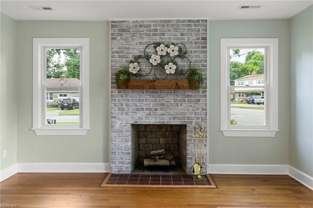 1 N Greenfield Ave, Hampton, VA 23666 - unfurnished living room featuring wood finished floors, healthy amount of natural light, and a brick fireplace