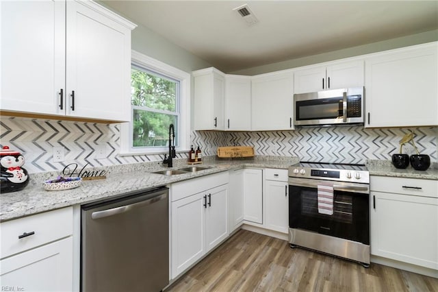 1 N Greenfield Ave, Hampton, VA 23666 - kitchen featuring appliances with stainless steel finishes, backsplash, and white cabinets