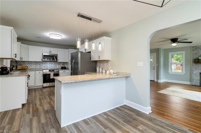 1 N Greenfield Ave, Hampton, VA 23666 - kitchen featuring stainless steel appliances, a peninsula, a ceiling fan, backsplash, and arched walkways