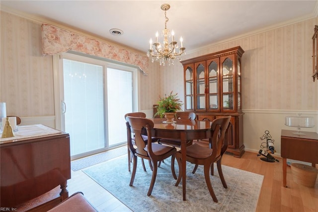 1328 Burlington Rd, Virginia Beach, VA 23464 - dining space with a chandelier, wood finished floors, a wainscoted wall, wallpapered walls, and crown molding