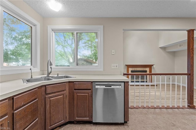 890 Brompton Ct, Newport News, VA 23608 - kitchen with dishwasher, a fireplace, light countertops, a textured ceiling, and light tile patterned flooring