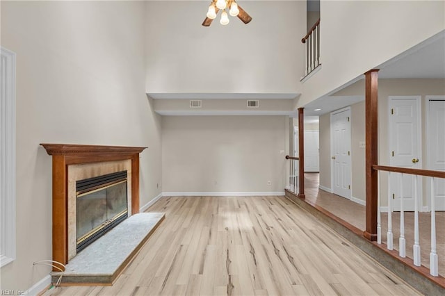 890 Brompton Ct, Newport News, VA 23608 - unfurnished living room with light wood-type flooring, a fireplace, ceiling fan, and a high ceiling