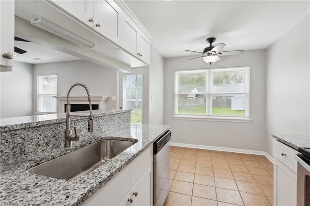809 Maitland Dr, Virginia Beach, VA 23454 - kitchen with stainless steel dishwasher, ceiling fan, white cabinets, light tile patterned flooring, and a fireplace