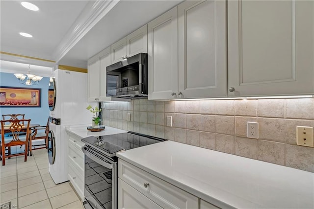 4004 Atlantic Ave Unit 309, Virginia Beach, VA 23451 - kitchen with stainless steel appliances, stacked washer and clothes dryer, ornamental molding, a chandelier, and backsplash