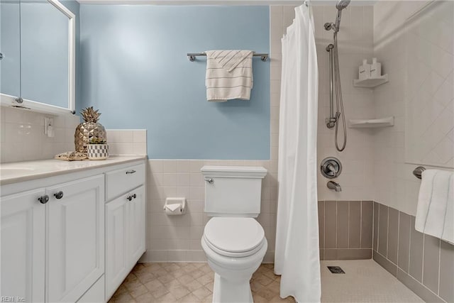 4004 Atlantic Ave Unit 309, Virginia Beach, VA 23451 - bathroom with vanity, tiled shower, tile walls, and wainscoting