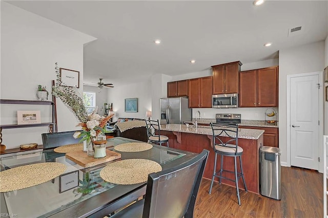 4321 Sconce, Williamsburg, VA 23188 - kitchen featuring stainless steel appliances, dark wood finished floors, a breakfast bar area, a kitchen island with sink, and recessed lighting