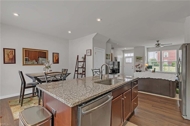 4321 Sconce, Williamsburg, VA 23188 - kitchen with appliances with stainless steel finishes, dark wood finished floors, a kitchen island with sink, light stone counters, and recessed lighting