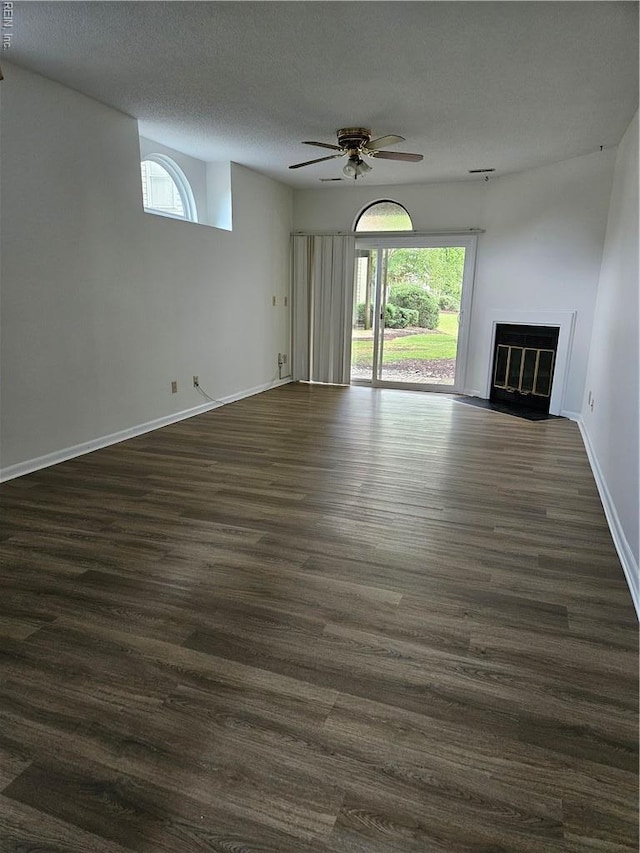 495 E Lake Cir, Chesapeake, VA 23322 - unfurnished living room featuring ceiling fan, plenty of natural light, a fireplace with flush hearth, dark wood-type flooring, and a textured ceiling