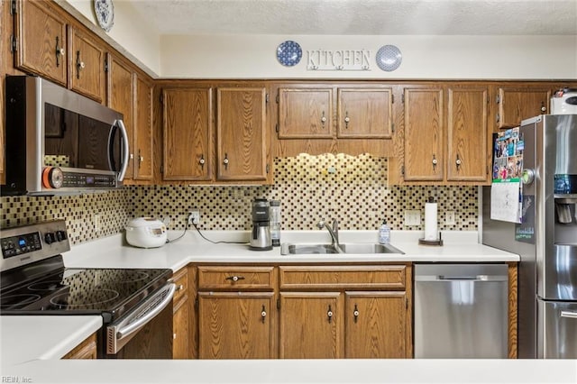19 Dawn Ln, Hampton, VA 23666 - kitchen featuring stainless steel appliances, brown cabinets, backsplash, light countertops, and a textured ceiling