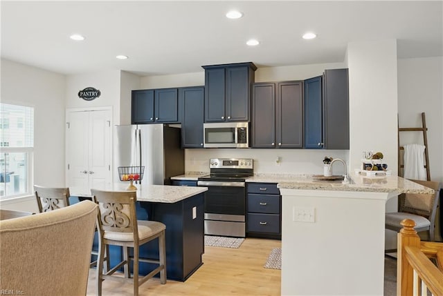 3102 Rollie Way, Chesapeake, VA 23323 - kitchen featuring stainless steel appliances, a breakfast bar, light wood-style flooring, a peninsula, and recessed lighting