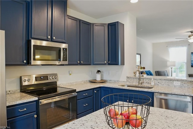 3102 Rollie Way, Chesapeake, VA 23323 - kitchen featuring appliances with stainless steel finishes, blue cabinetry, light stone countertops, open floor plan, and a ceiling fan