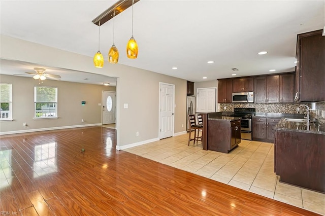 305 Roane Dr, Hampton, VA 23669 - kitchen featuring appliances with stainless steel finishes, dark brown cabinets, a breakfast bar area, a kitchen island, and open floor plan