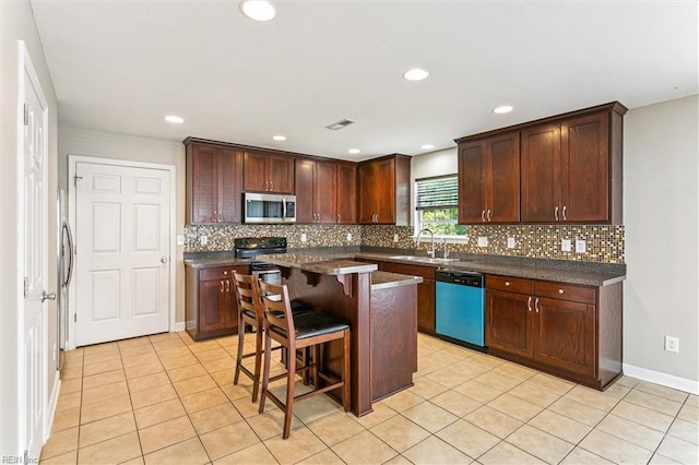 305 Roane Dr, Hampton, VA 23669 - kitchen with dishwashing machine, stainless steel microwave, dark countertops, a breakfast bar, and decorative backsplash