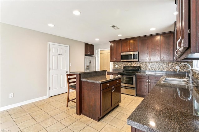 305 Roane Dr, Hampton, VA 23669 - kitchen with appliances with stainless steel finishes, tasteful backsplash, a breakfast bar area, light tile patterned flooring, and a kitchen island