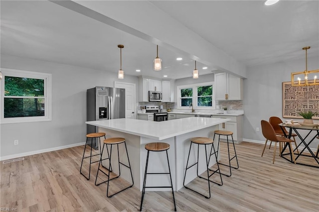 1226 Penniman Rd, Williamsburg, VA 23185 - kitchen with stainless steel appliances, a breakfast bar area, tasteful backsplash, a chandelier, and recessed lighting