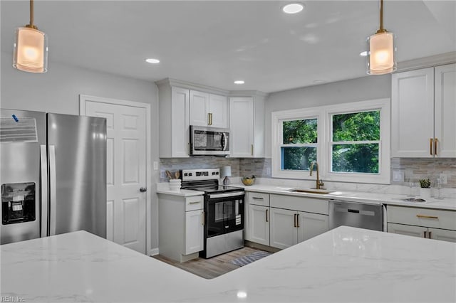 1226 Penniman Rd, Williamsburg, VA 23185 - kitchen featuring appliances with stainless steel finishes, decorative backsplash, recessed lighting, white cabinets, and hanging light fixtures