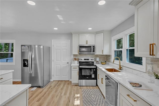 1226 Penniman Rd, Williamsburg, VA 23185 - kitchen with appliances with stainless steel finishes, backsplash, white cabinetry, light wood-style flooring, and recessed lighting