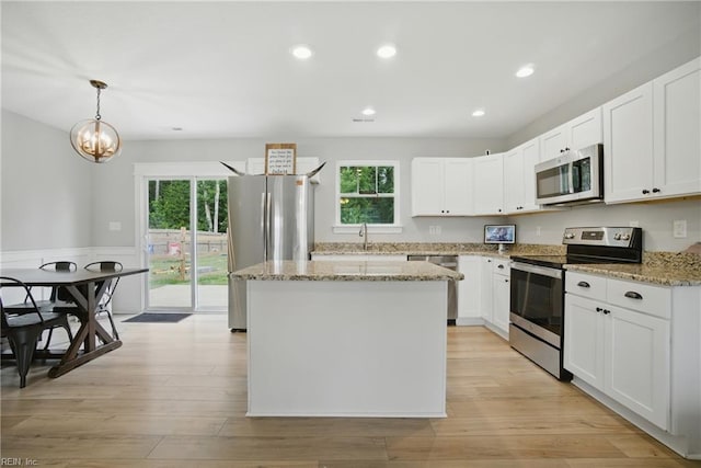 116 B St, Moyock, NC 27958 - kitchen with appliances with stainless steel finishes, a kitchen island, recessed lighting, light stone countertops, and white cabinetry