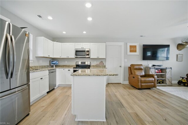116 B St, Moyock, NC 27958 - kitchen with appliances with stainless steel finishes, open floor plan, recessed lighting, light stone countertops, and light wood-style floors