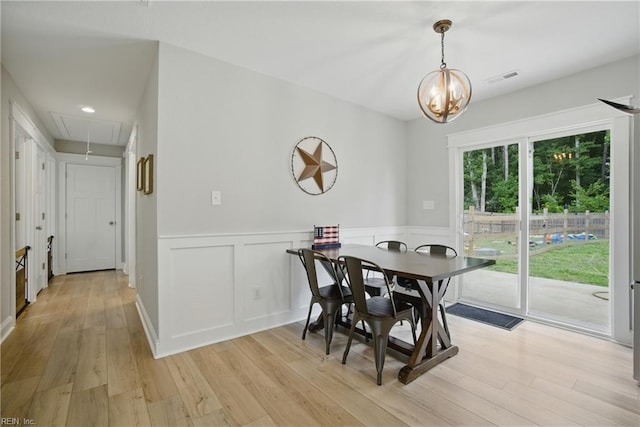 116 B St, Moyock, NC 27958 - dining space with attic access, light wood-style floors, wainscoting, a chandelier, and a decorative wall