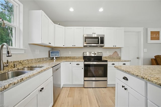 116 B St, Moyock, NC 27958 - kitchen with appliances with stainless steel finishes, recessed lighting, white cabinetry, light wood-style floors, and light stone counters