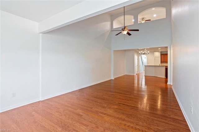 4048 Coronation, Williamsburg, VA 23188 - unfurnished living room with a chandelier, ceiling fan, wood finished floors, and a towering ceiling