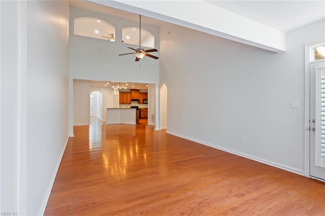 4048 Coronation, Williamsburg, VA 23188 - unfurnished living room with arched walkways, ceiling fan, light wood-style flooring, a towering ceiling, and recessed lighting