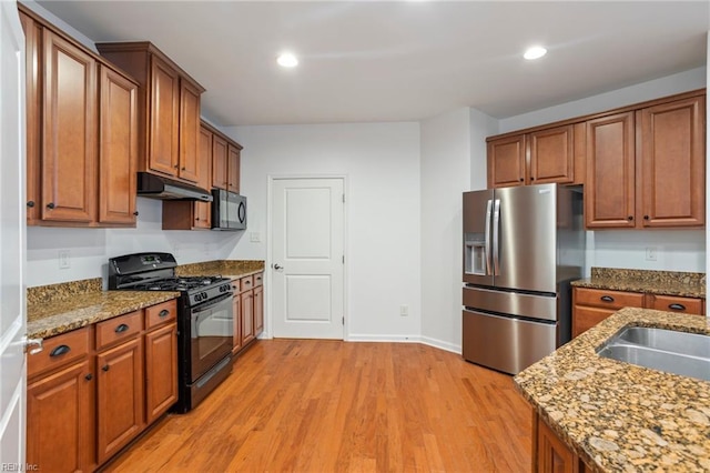 4048 Coronation, Williamsburg, VA 23188 - kitchen with black appliances, under cabinet range hood, light wood-style flooring, brown cabinetry, and recessed lighting