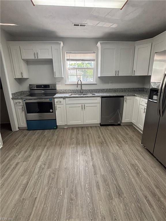 219 Gale Ave, Chesapeake, VA 23323 - kitchen featuring stainless steel appliances, light wood-type flooring, and white cabinetry