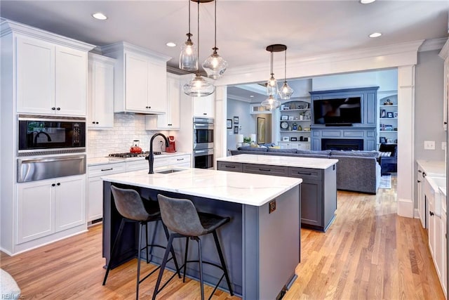 1808 John Hancock Rd, Williamsburg, VA 23185 - kitchen with a warming drawer, a center island with sink, stainless steel appliances, open floor plan, and ornamental molding