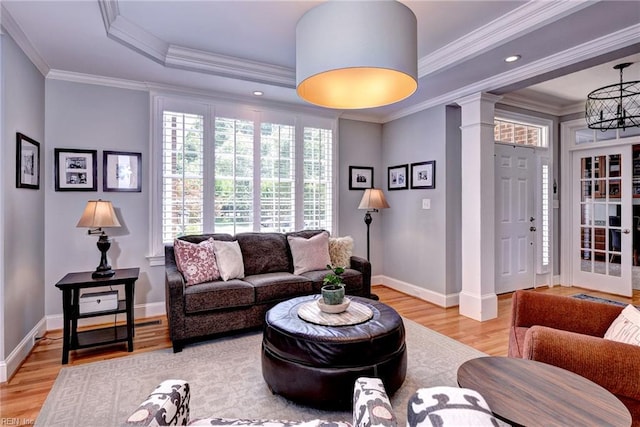 1808 John Hancock Rd, Williamsburg, VA 23185 - living area featuring ornate columns, light wood-style flooring, a chandelier, ornamental molding, and a raised ceiling