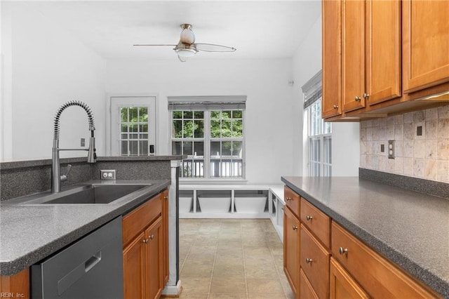 1028 Cathedral Dr, Suffolk, VA 23434 - kitchen featuring stainless steel dishwasher, backsplash, dark countertops, a ceiling fan, and brown cabinets