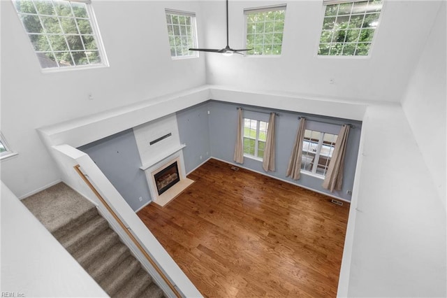 1028 Cathedral Dr, Suffolk, VA 23434 - unfurnished living room with healthy amount of natural light, a fireplace with flush hearth, a towering ceiling, wood finished floors, and stairway