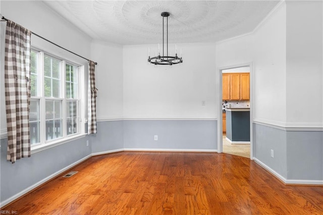 1028 Cathedral Dr, Suffolk, VA 23434 - empty room featuring a chandelier, wood finished floors, and crown molding