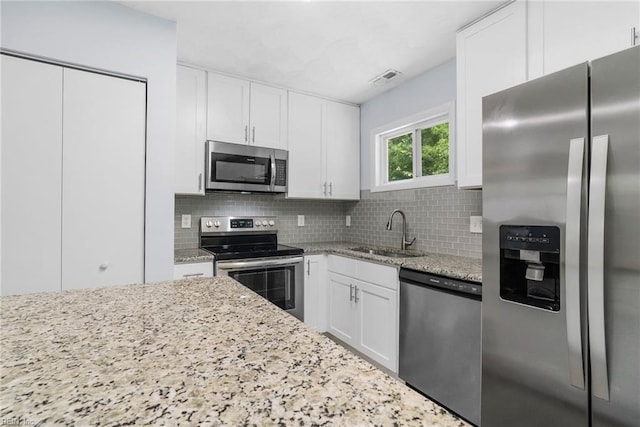 1833 Darville Dr, Hampton, VA 23663 - kitchen featuring stainless steel appliances, decorative backsplash, light stone countertops, and white cabinets