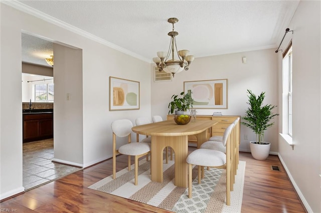 208 Sherbrooke Dr, Newport News, VA 23602 - dining space with wood finished floors, ornamental molding, a chandelier, and a textured ceiling