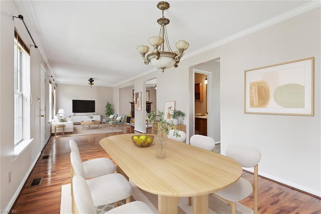 208 Sherbrooke Dr, Newport News, VA 23602 - dining space featuring healthy amount of natural light, a chandelier, wood finished floors, and ornamental molding