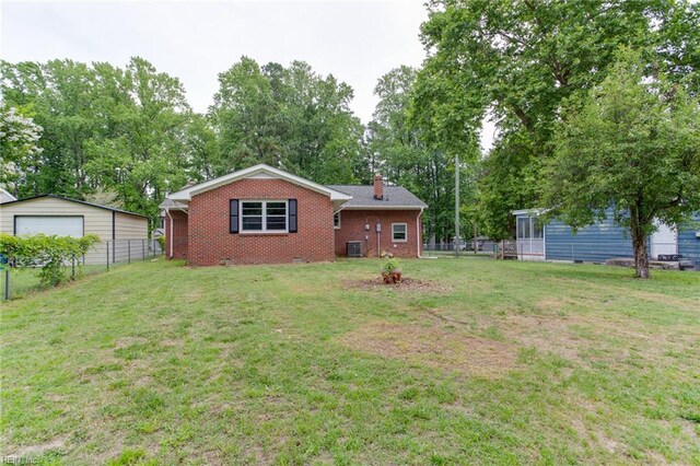 194 Railroad St, Williamsburg, VA 23185 - back of house with a detached garage, brick siding, a chimney, and view of wooded area