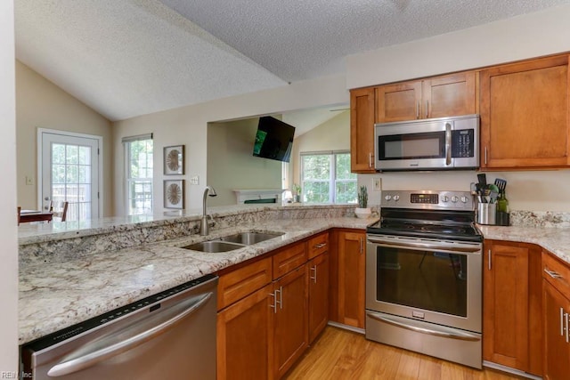 5225 Thatcher Way, Virginia Beach, VA 23456 - kitchen featuring stainless steel appliances, lofted ceiling, brown cabinets, light wood-style floors, and a textured ceiling