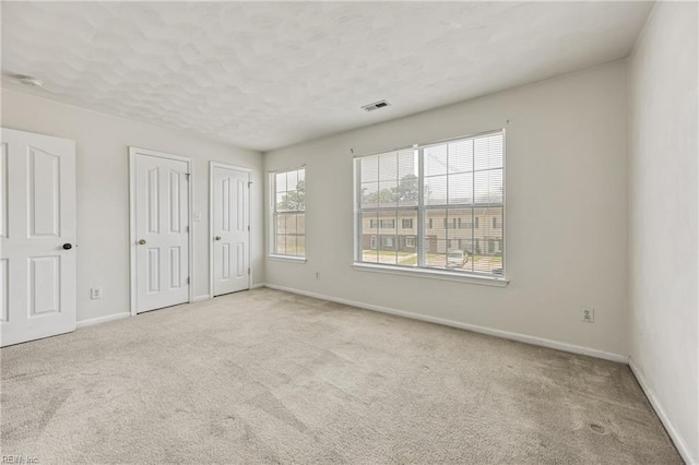 48 Terri Sue Ct, Hampton, VA 23666 - unfurnished bedroom featuring multiple closets, carpet floors, and a textured ceiling